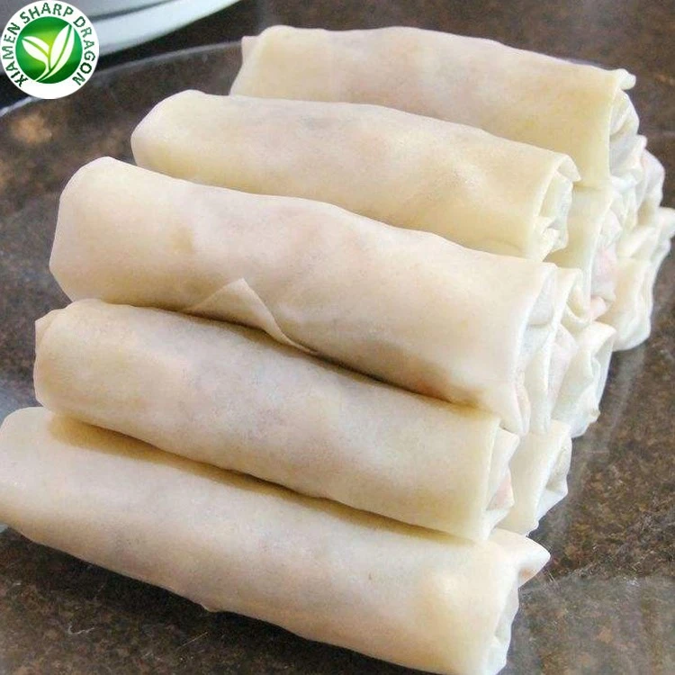 Unbrowned spring rolls and their folded wrappers Pale spring rolls stacked with folded wrapper seams visible